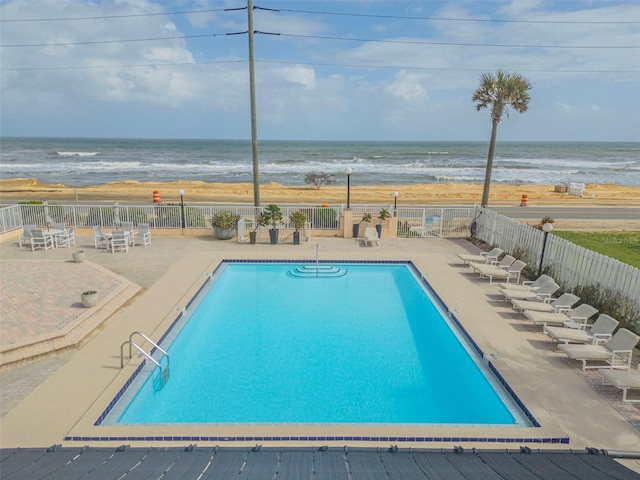 view of pool with a patio and a water view