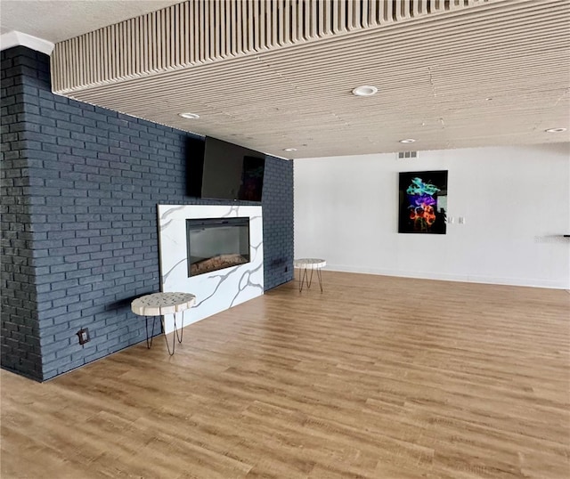 unfurnished living room featuring a fireplace and light hardwood / wood-style floors