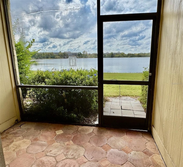 interior space featuring plenty of natural light, wooden walls, and a water view