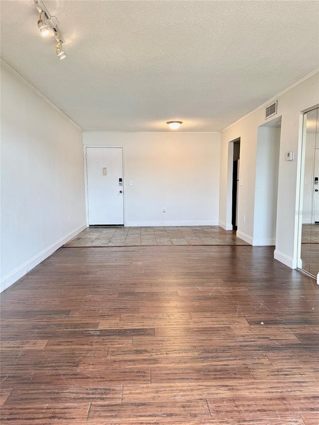 unfurnished room with a textured ceiling and wood-type flooring