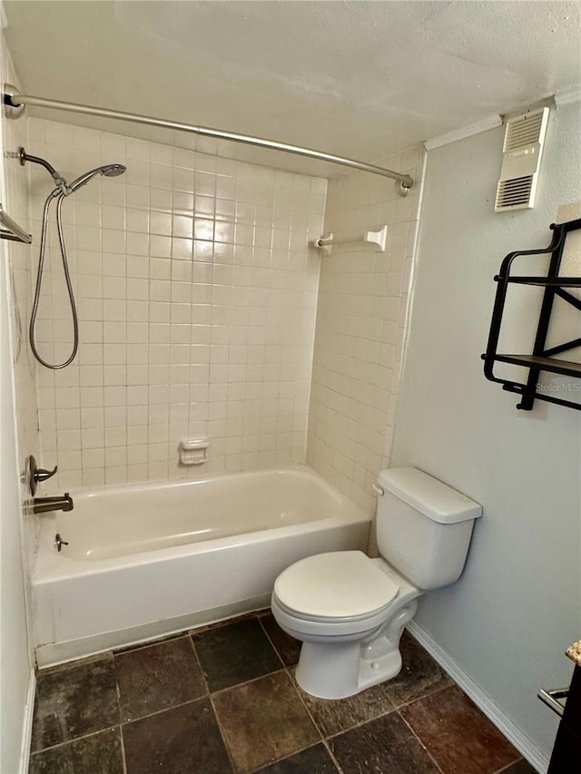 bathroom with tiled shower / bath combo and toilet