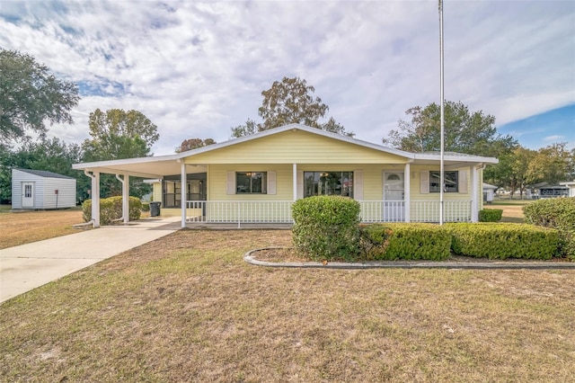 view of front facade with a carport, covered porch, and a front lawn