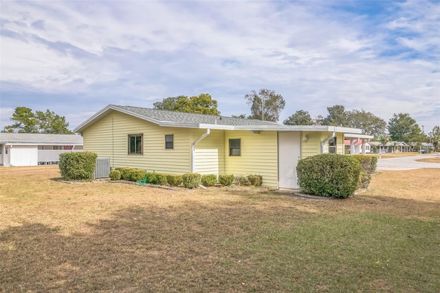 exterior space with central air condition unit and a front lawn