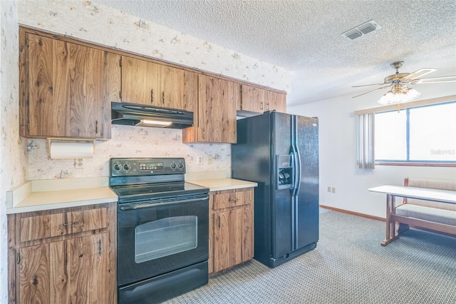 10170 SW 96th Ct, Ocala, FL 34481 - kitchen with black appliances, under cabinet range hood, light colored carpet, brown cabinetry, and a textured ceiling