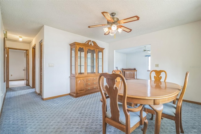 dining area featuring ceiling fan, carpet, and a textured ceiling