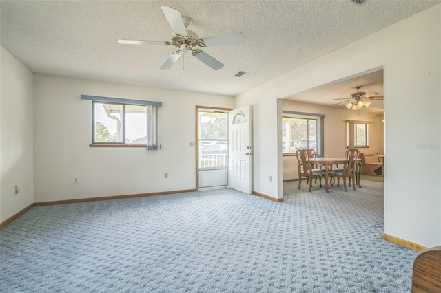 spare room with carpet, ceiling fan, and a textured ceiling