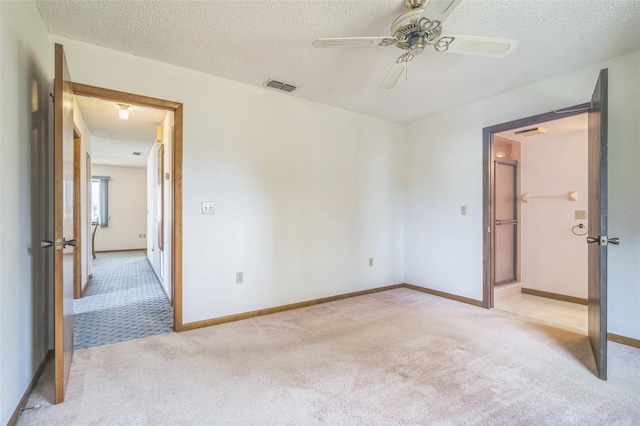 carpeted empty room with ceiling fan and a textured ceiling