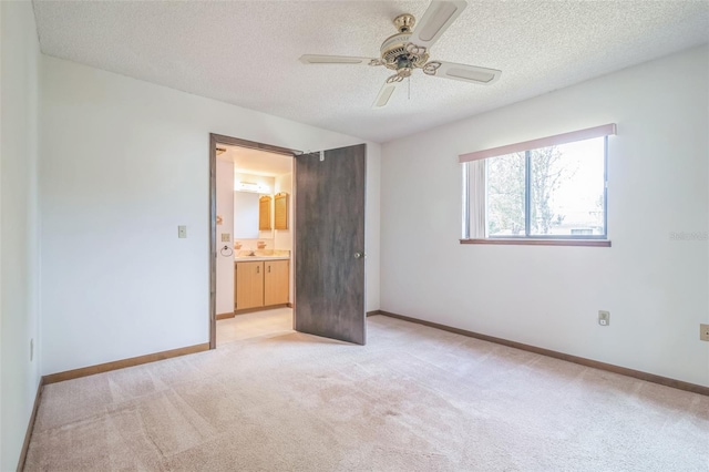 unfurnished bedroom with ceiling fan, a textured ceiling, and light carpet