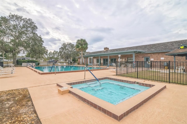 view of pool with a community hot tub and a patio