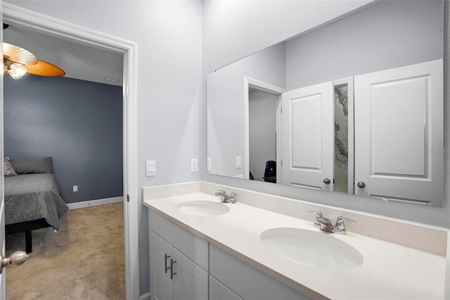 full bathroom featuring ensuite bathroom, double vanity, a sink, and baseboards