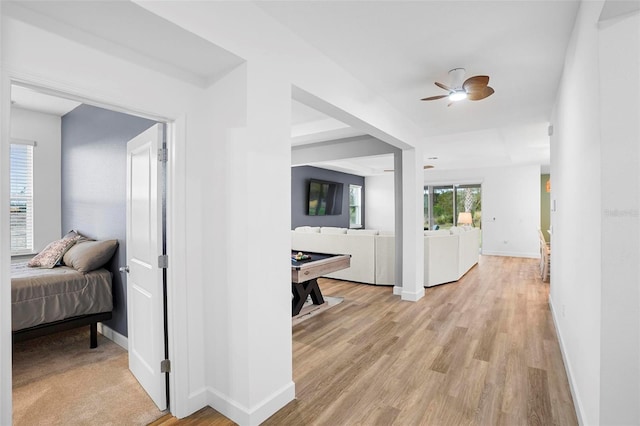 hallway with light wood-type flooring and baseboards