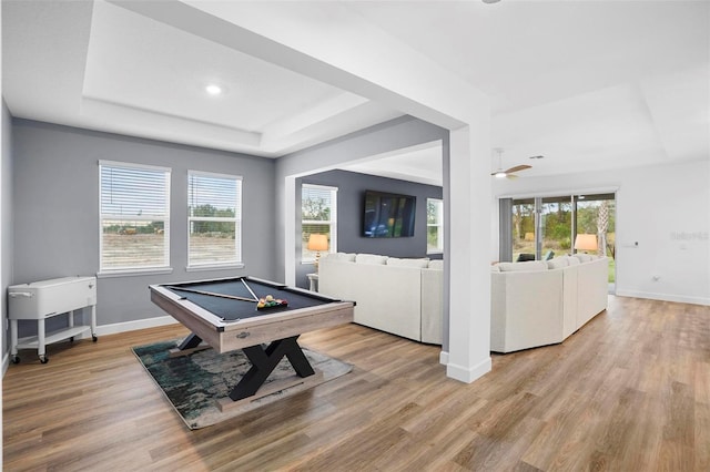 playroom featuring baseboards, pool table, a tray ceiling, and light wood-style floors