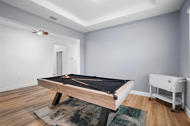 playroom with a tray ceiling, baseboards, visible vents, and wood finished floors