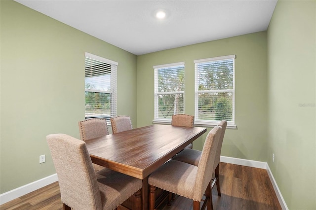 dining area with baseboards and wood finished floors