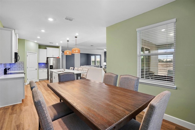 dining space featuring light wood-style flooring, visible vents, baseboards, and recessed lighting