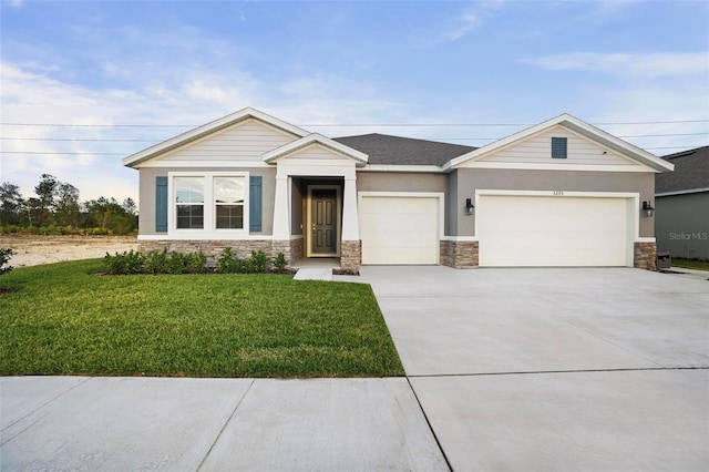 view of front facade with a garage, stone siding, driveway, and a front lawn