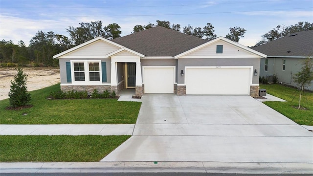 craftsman house with a garage, stone siding, concrete driveway, and a front yard