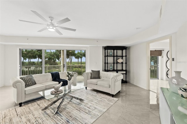 living room featuring ceiling fan and a wealth of natural light