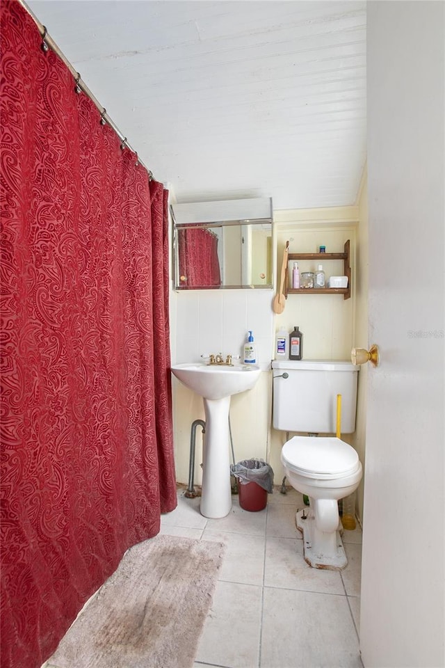 bathroom featuring toilet, sink, and tile patterned floors