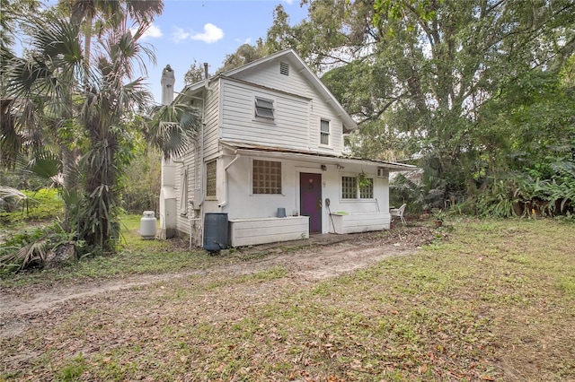 view of front of home with covered porch and a front lawn