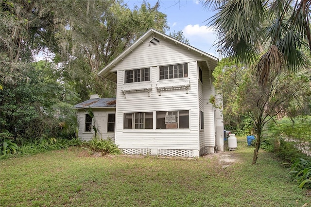 rear view of property featuring a lawn