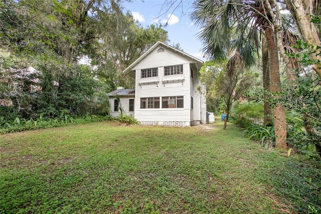 rear view of house featuring a lawn