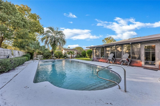 view of swimming pool featuring a patio area and a sunroom