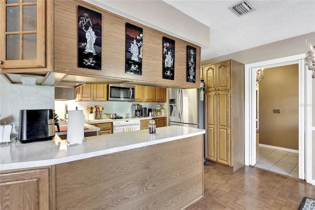 kitchen featuring sink, kitchen peninsula, stainless steel appliances, and light parquet flooring