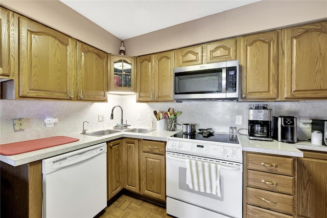 kitchen with white appliances, backsplash, light parquet flooring, and sink