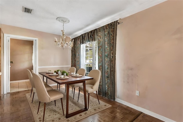 dining room with parquet flooring and a chandelier