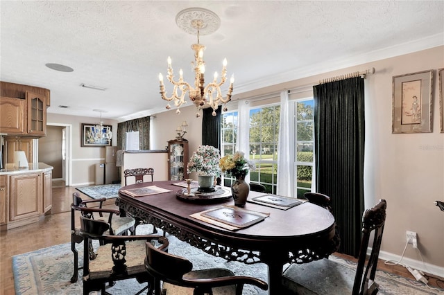 dining area with light hardwood / wood-style floors, a textured ceiling, and a chandelier