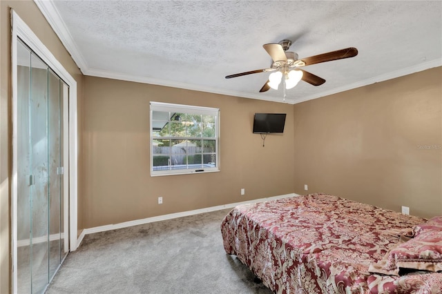 bedroom featuring carpet, ceiling fan, a textured ceiling, ornamental molding, and a closet