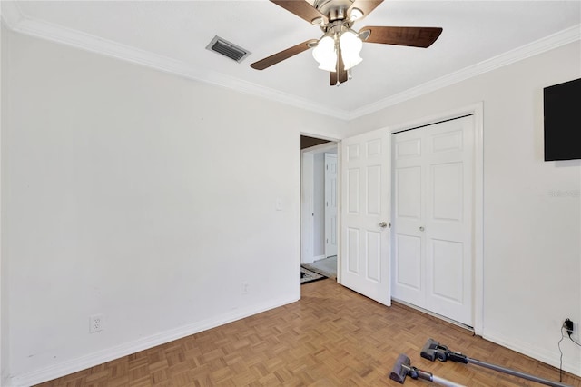 unfurnished bedroom with a closet, crown molding, light parquet flooring, and ceiling fan