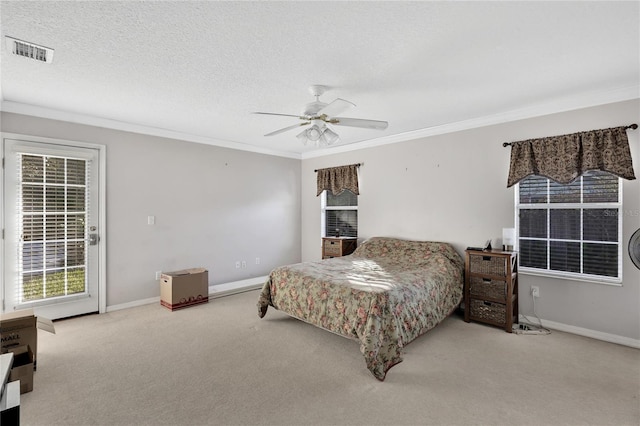 carpeted bedroom with ceiling fan, ornamental molding, and a textured ceiling