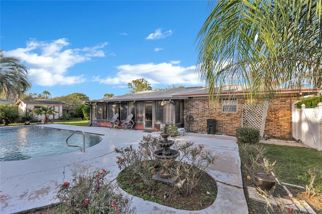 view of swimming pool featuring a patio and a sunroom