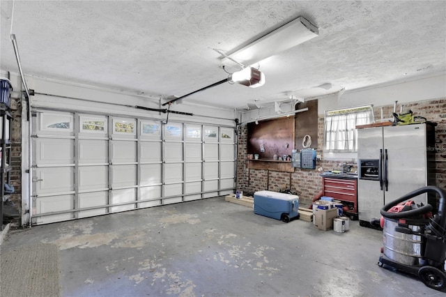 garage with stainless steel fridge and a garage door opener