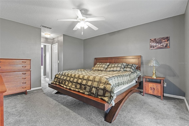 carpeted bedroom featuring ceiling fan and a textured ceiling