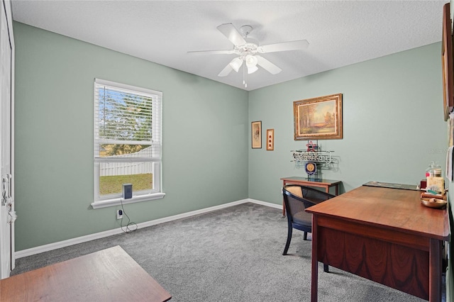 carpeted office featuring a textured ceiling and ceiling fan