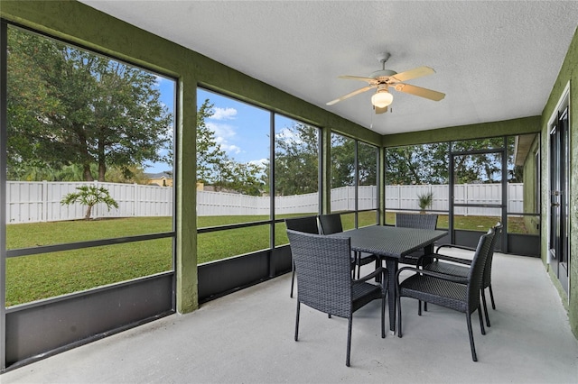 sunroom / solarium featuring a healthy amount of sunlight and ceiling fan