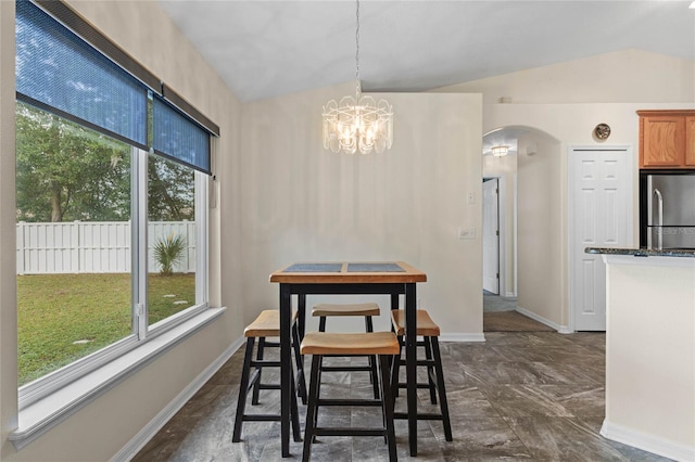 dining room with a chandelier and vaulted ceiling