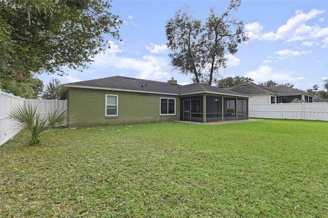 rear view of house with a sunroom and a lawn