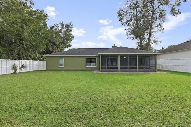 back of property featuring a lawn and a sunroom