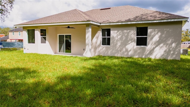 rear view of house featuring central AC unit, a lawn, and ceiling fan