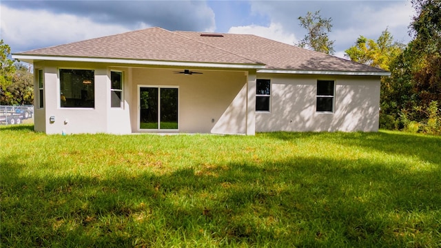 rear view of house featuring ceiling fan and a lawn