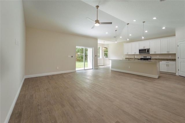 kitchen featuring a center island with sink, light wood-type flooring, range with electric cooktop, sink, and white cabinets