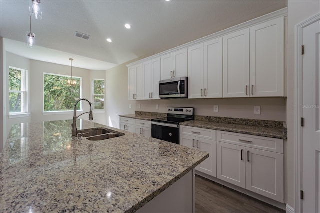 kitchen featuring decorative light fixtures, white cabinetry, sink, and stainless steel appliances