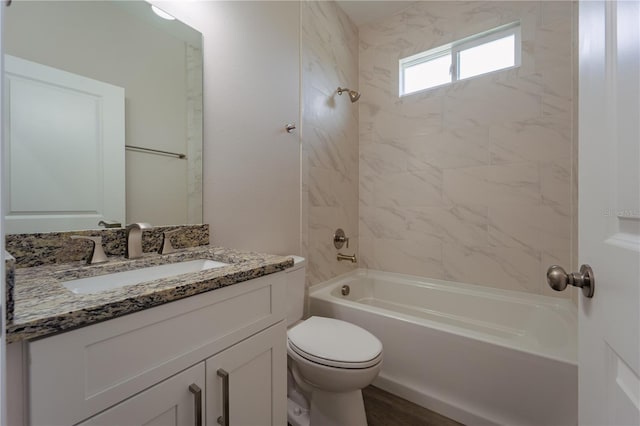 full bathroom with toilet, vanity, and tiled shower / bath