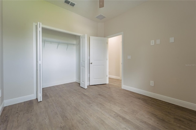 unfurnished bedroom featuring light hardwood / wood-style floors, ceiling fan, and a closet