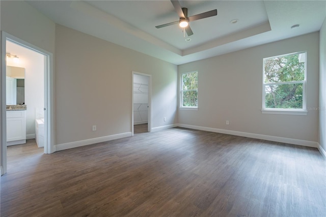 unfurnished room featuring hardwood / wood-style floors, ceiling fan, and a raised ceiling