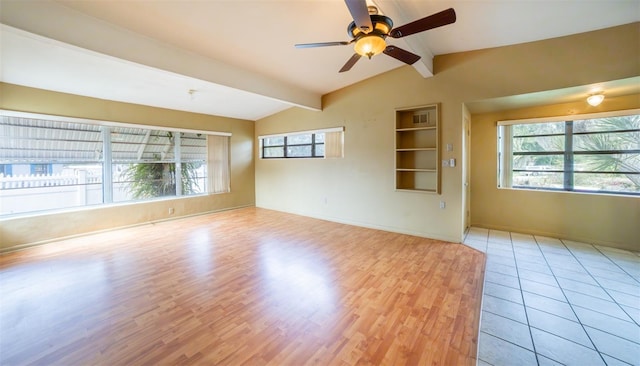 empty room with lofted ceiling with beams, light hardwood / wood-style floors, and ceiling fan